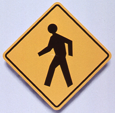 Yellow square road sign that has black outline of a person walking