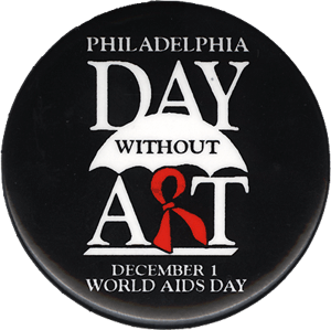 A black button with the words Philadelphia Day Without Art: December 1 World AIDS Day written in white lettering. The letter R in art red and is designed to look like an AIDS ribbon.