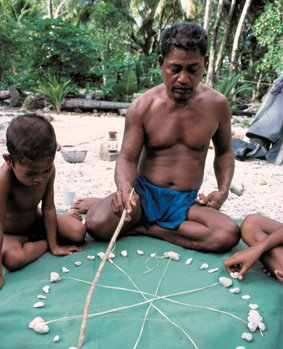 Micronesian wayfinder, Mau Piailug, uses a star compass to teach navigation to his son and others.