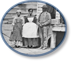 Black and white photograph of two African American women and one African American man standing in front of a United States Christian Commission storehouse in Washington, D.C., April 1865. Courtesy Library of Congress. 