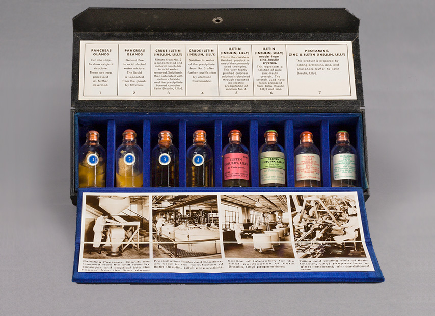 Opened rectangular sales kit with eight glass vials of insulin and includes labels and photographs
