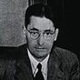 Black-and-white photo of Florey at a desk up which there are some papers