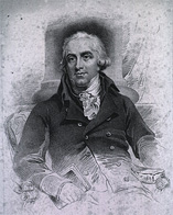 William Buchan wearing a double breasted jacket sitting down.
