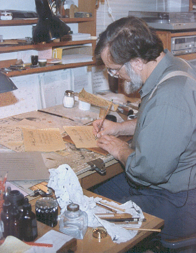 Mohamed Zakariya seated at his workbench writing Arabic script on a piece of paper.