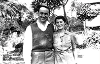 Portrait of a white man and white woman standing next to each other outdoors.