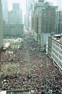 Sky view of street with a large crowd of people gathered in NYC.