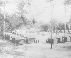 Camp E.A. Perry, a detention camp established by the U.S. Marine Hospital Service on the border between Georgia and Florida during the yellow fever epidemic of 1888. The camp is primarily small wooden buildings in a large square and there are people standing near the buildings.