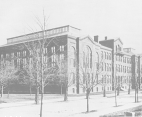 A black and white front angled view of the Army Medical Museum and Library on the Mall - a three story building surrounded by several small trees.