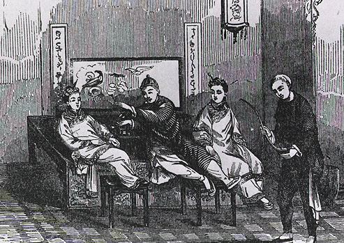 Four Chinese men in traditional dress smoke opium on a bench.
