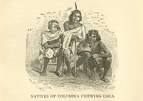 Three native Columbians in traditional dress sitting chewing coca leaves.