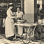 Ten White female nurses in white are at different stations of a kitchen preparing food.
