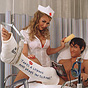 A White woman in white with cleavage showing, seductively standing next to a White male patient.
