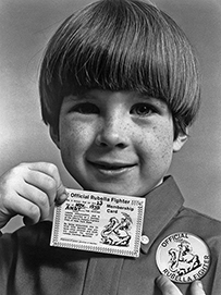 A photograph of a smiling white boy holding a card