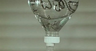 A medical drip container made of glass.
