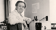 Florence Sabin at a desk with a microscope