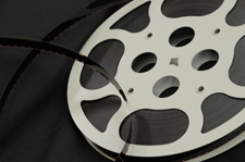 Color image of a 16 millimeter motion picture film wound on a metal reel.