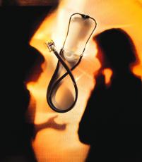 Photograph of a stethoscope with the shadows of two women in the background