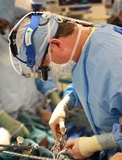 Photograph of a male surgeon performing surgery