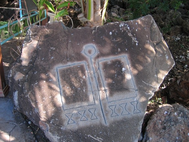 Color image of a rock inscribed with various symbols.