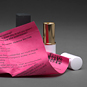Pink paper next to open lipstick case.