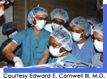 Group of men and women in green surgical scrubs, caps and masks observing an operation.  Courtesy Edward E. Cornwell, III, M.D.