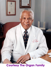 Man in white medical coat seated at a desk.  Courtesy The Organ Family
