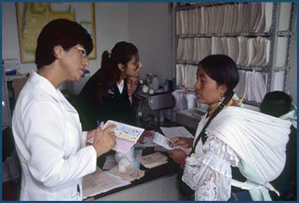 Mother and child speaking to staff member at a local clinic