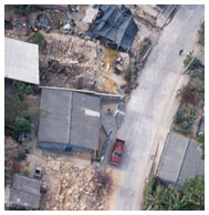 Aerial view of damaged buildings and road