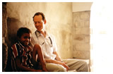 Dr. Paul Farmer sits with a young boy.