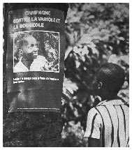 Two children read a smallpox eradication poster pinned to a tree