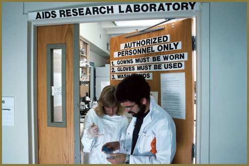National Institutes of Health AIDS researchers discuss research in doorway of laboratory