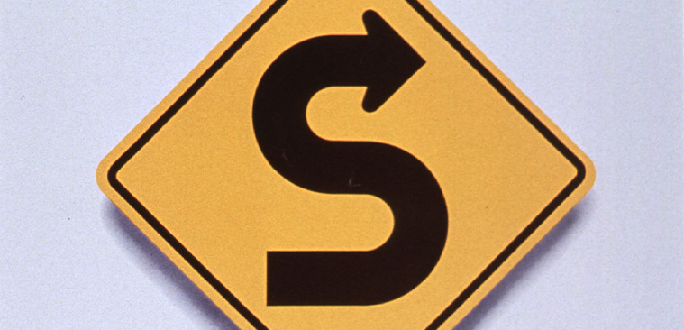 Yellow square road sign that has black curved arrow indicating curves in the roadway ahead above text