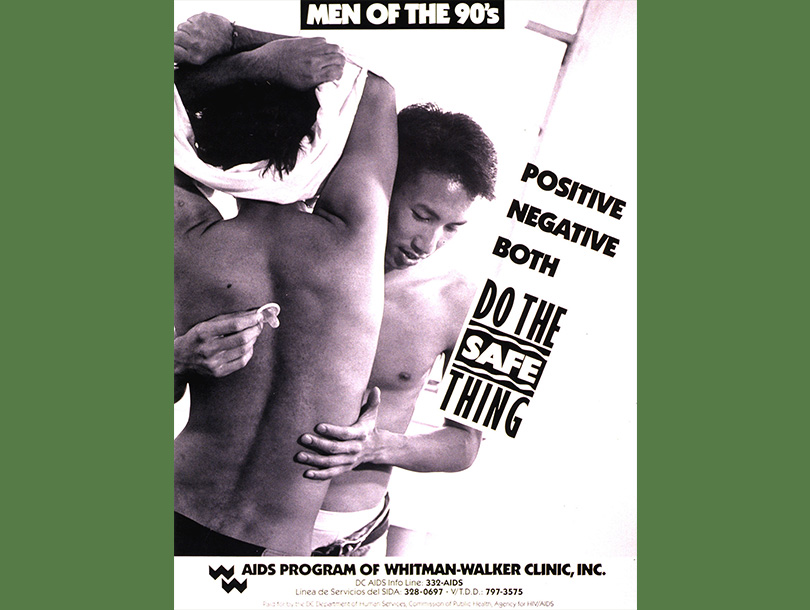 Color photograph of two young men; one has back turned and is removing his shirt, while the other man holds him and has a condom in one hand