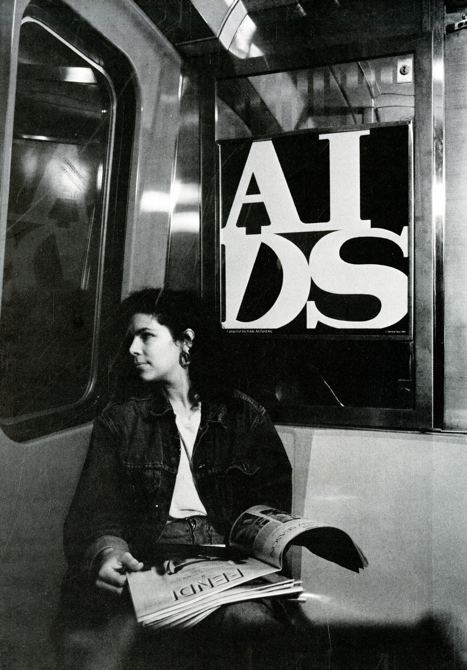 A White woman sitting in a subway car holding magazines, behind her head hangs a poster saying “AIDS”