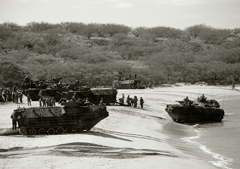 Black and white photograph of tanks and APC’s landing on beach for military exercises.