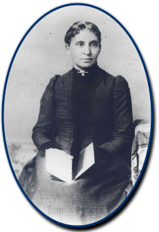 Black and white photograph of Charlotte Forten sitting in a chair with an open book in her lap. Courtesy Moorland Spingarn Research Center, Howard University.