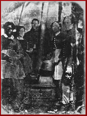 Black and white photograph of an African American woman, two white women, and two white soldiers in uniform standing beside a stove inside a tent. Courtesy National Museum of Civil War Medicine. 