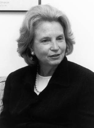 Dr. Kathleen M. Foley, a White woman in a dark suit sitting on a couch.