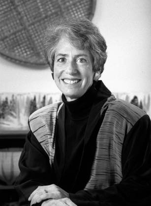 Dr. Karen Hein, a smiling White woman seated with her hands crossed in a room.