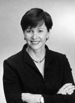 Dr. Linda S. Austin, a White woman smiling and standing with her arms crossed in a dark jacket.