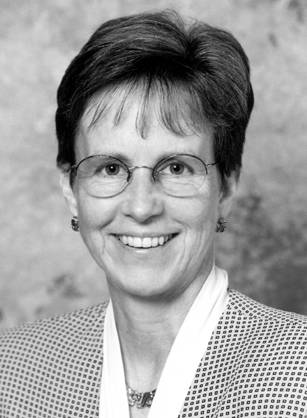 Dr. Ann Connor Jobe, a White woman with cropped hair and glasses posing for portrait.