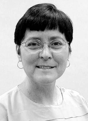 Dr. Theresa Loya, a White woman with glasses smiling for her portrait.