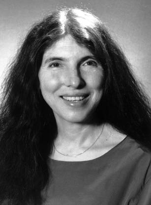 Dr. Stephanie Joan Woolhandler, a White woman with long dark hair smiling for her portrait.