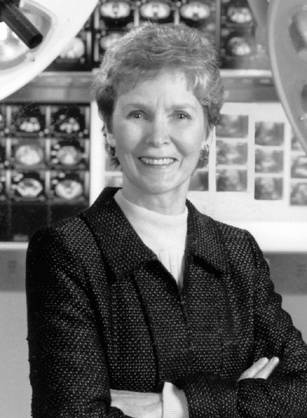 Dr. Kathryn Dorothy Duncan Anderson, a White woman posing in front of x-rays & radiology equipment.