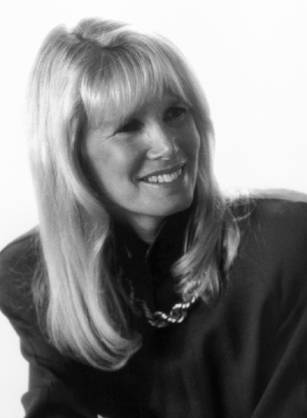 Dr. Susan J. Blumenthal, a smiling White woman with blonde hair posing in green professional attire.
