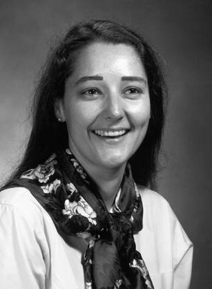 Dr. Patricia StandTal Clarke, a young, smiling American Indian woman posing for her portrait.