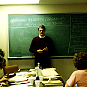 Man standing in front of chalk board.