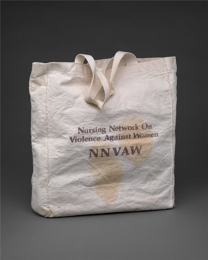 White cloth bag with handle, with text that identifies the organization.