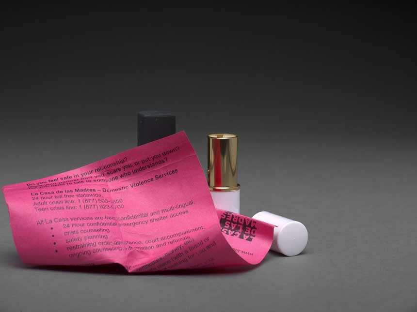 Pink paper next to open lipstick case.