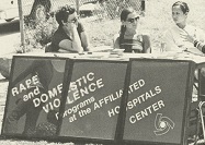 Four women sitting at a table with identifying sign.